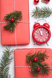 Photo of Flat lay composition with Christmas gift and alarm clock on white background. Boxing day
