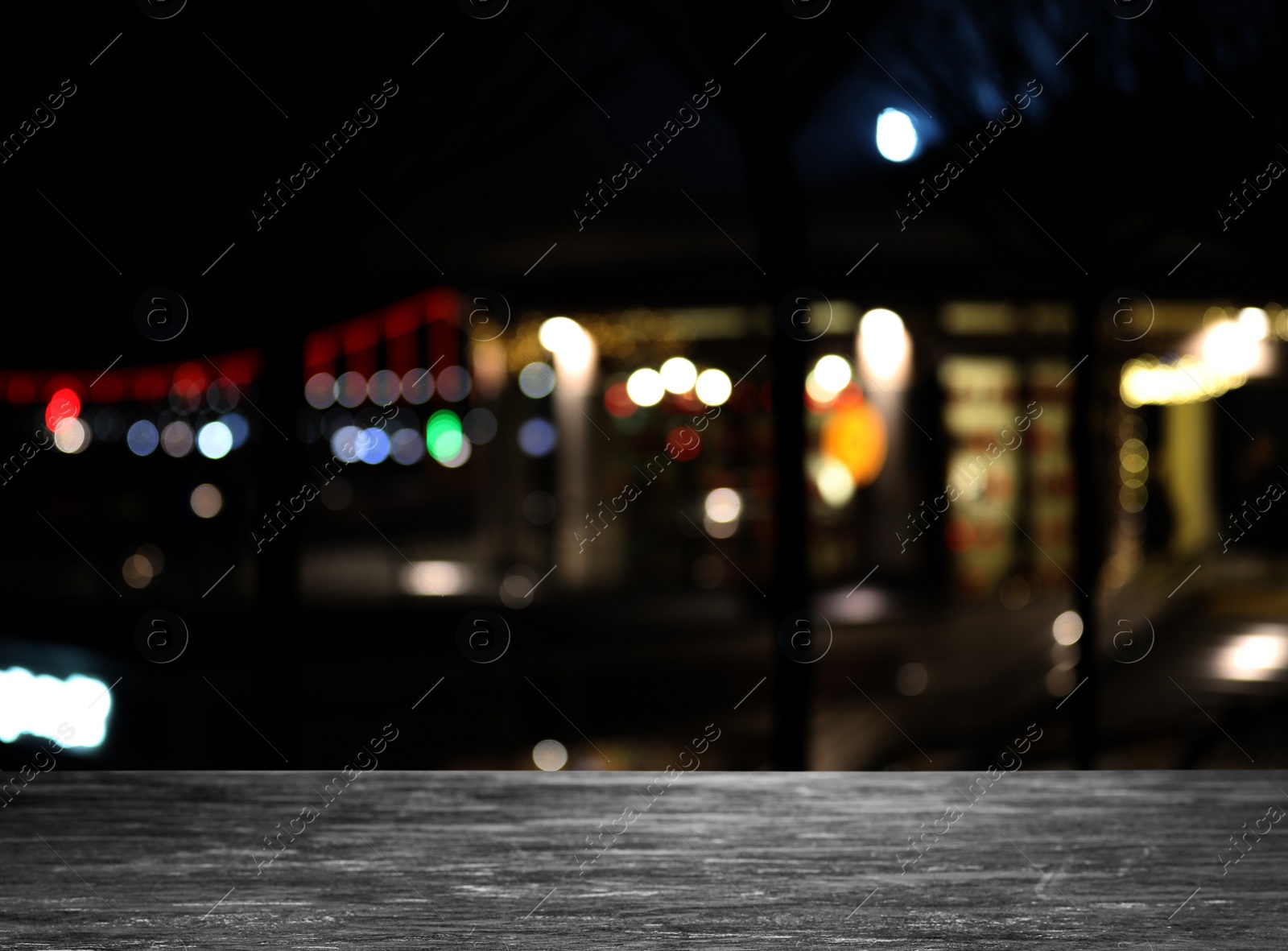 Image of Empty stone surface and blurred view of night city