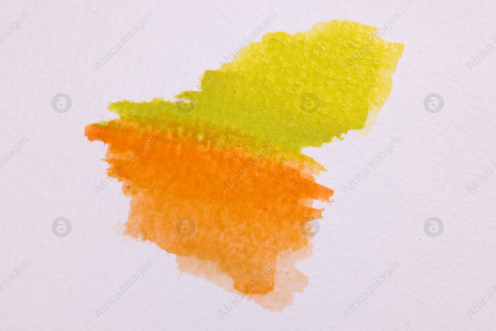 Photo of Blot of bright watercolor paints on white paper, top view