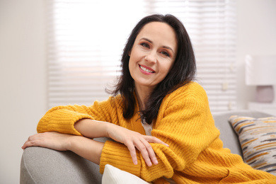 Photo of Beautiful mature woman on sofa at home