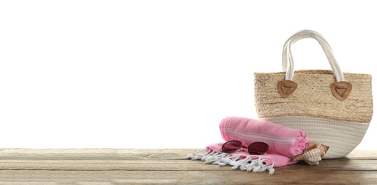 Stylish bag with beach accessories on wooden table. Space for text