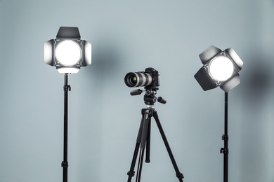 Professional video camera and lighting equipment on grey background