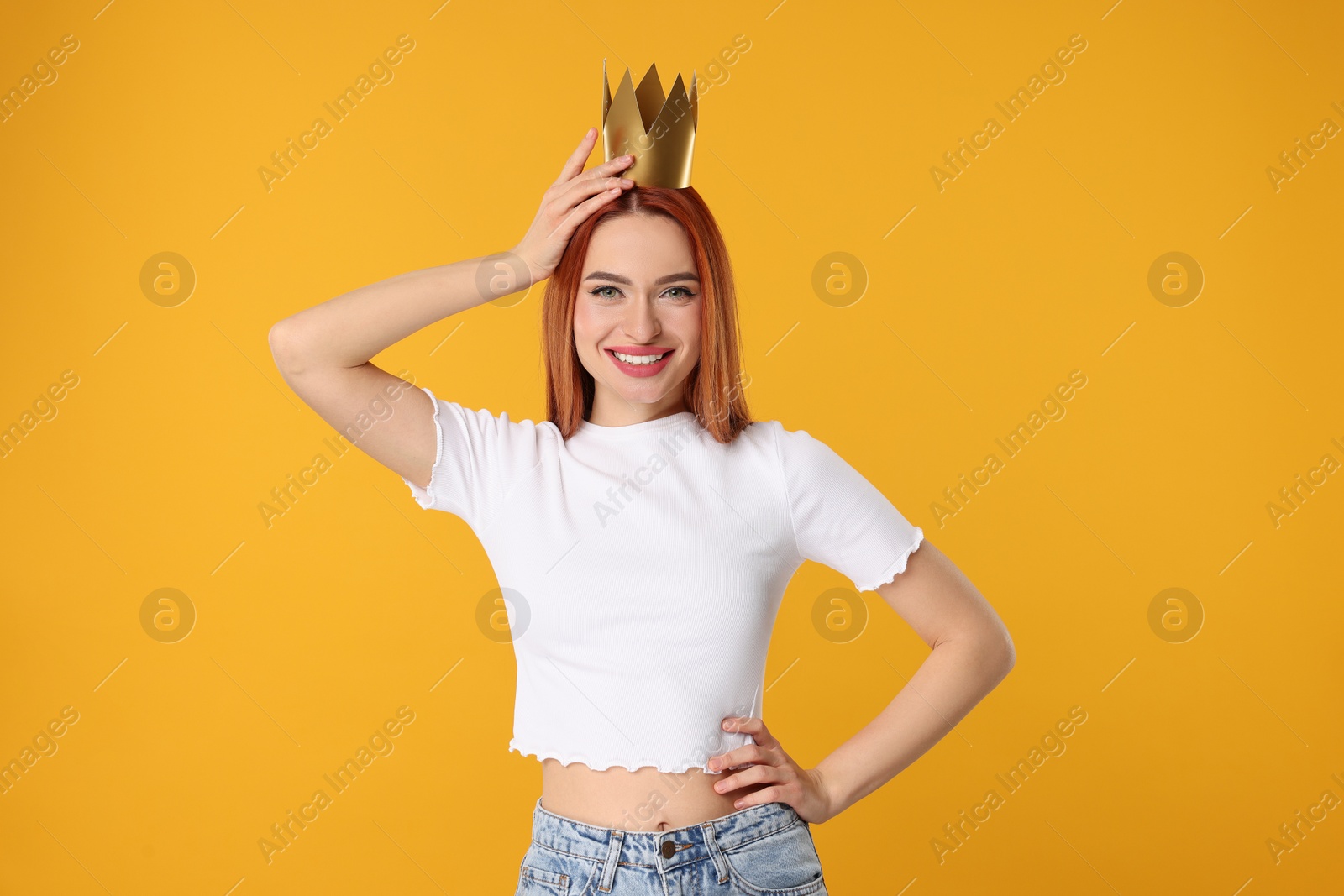 Photo of Beautiful young woman with princess crown on orange background