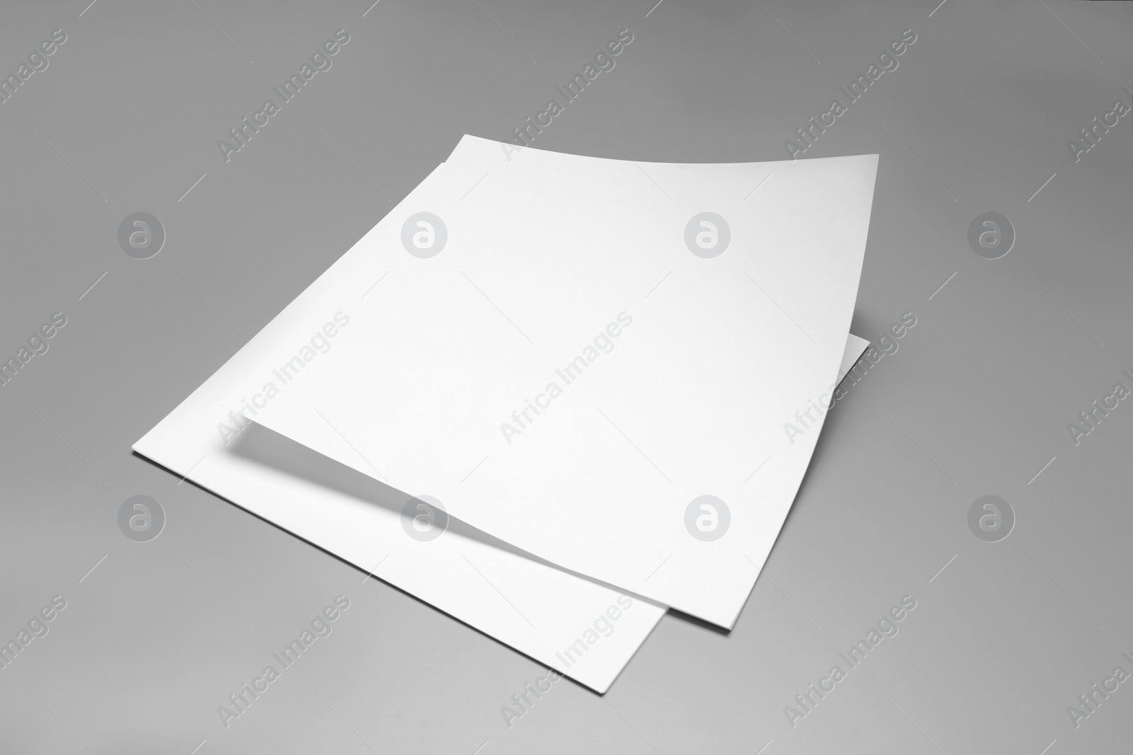 Photo of Blank paper sheets for brochure on grey background. Mock up