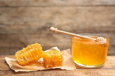 Photo of Tasty honey and combs on wooden table