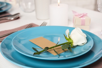 Photo of Elegant festive table setting with blank card in restaurant