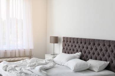 Photo of Soft white pillows on comfortable bed indoors