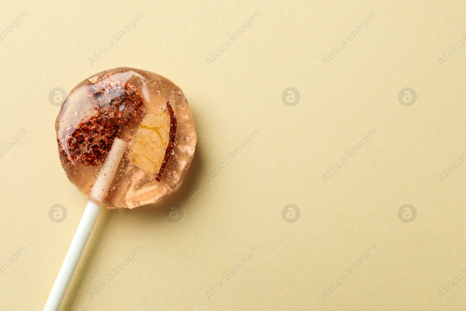 Photo of Sweet colorful lollipop with berries on beige background, top view. Space for text