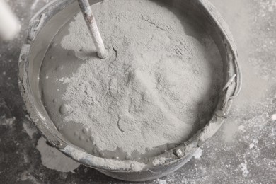 Photo of Bucket with concrete and cement powder indoors, closeup