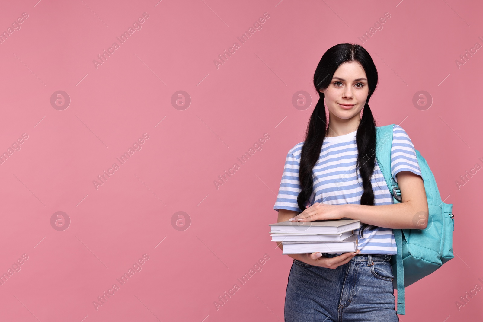 Photo of Student with books and backpack on pink background. Space for text