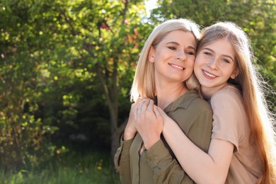 Happy mother with her daughter spending time together in park on sunny day