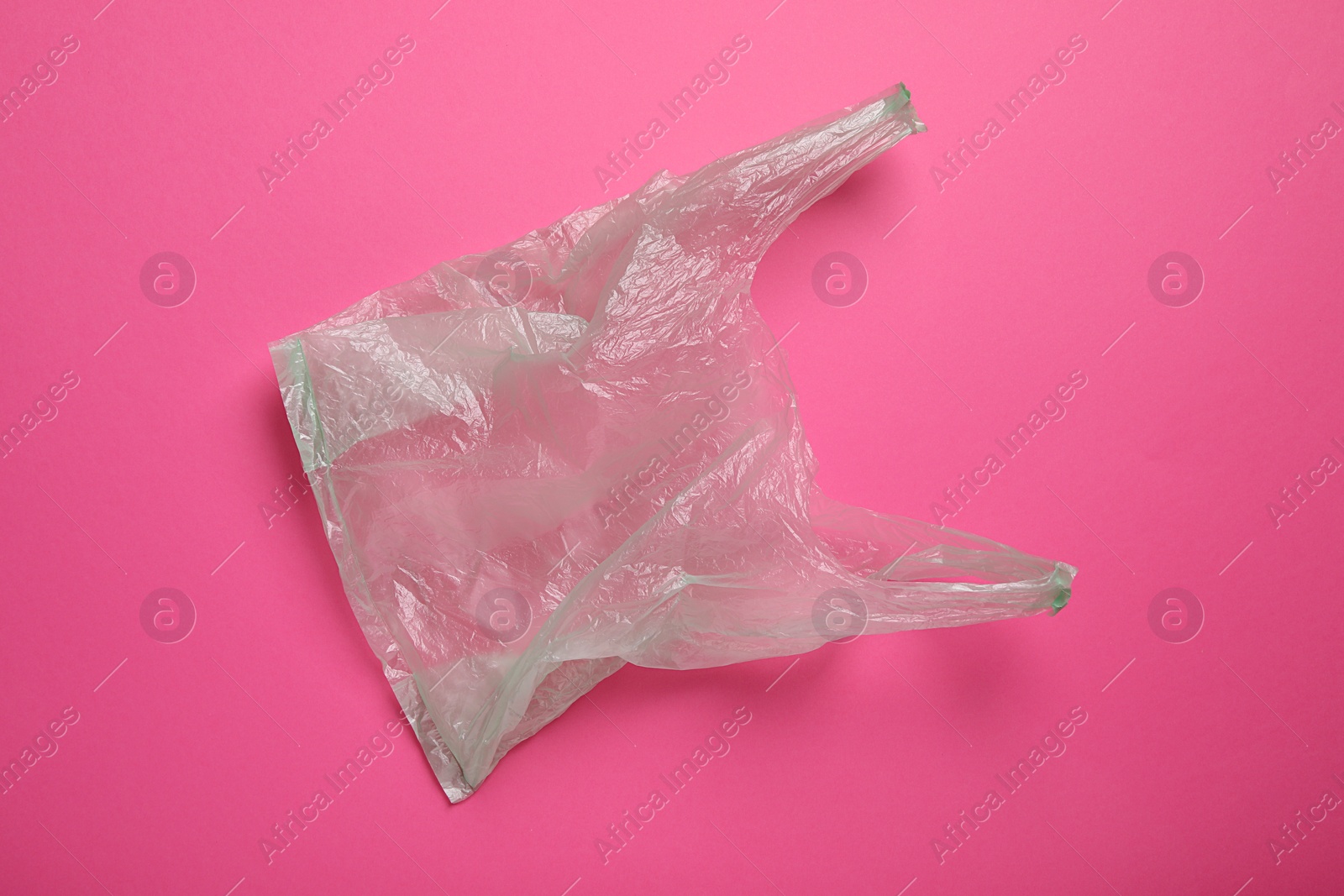 Photo of One plastic bag on pink background, top view