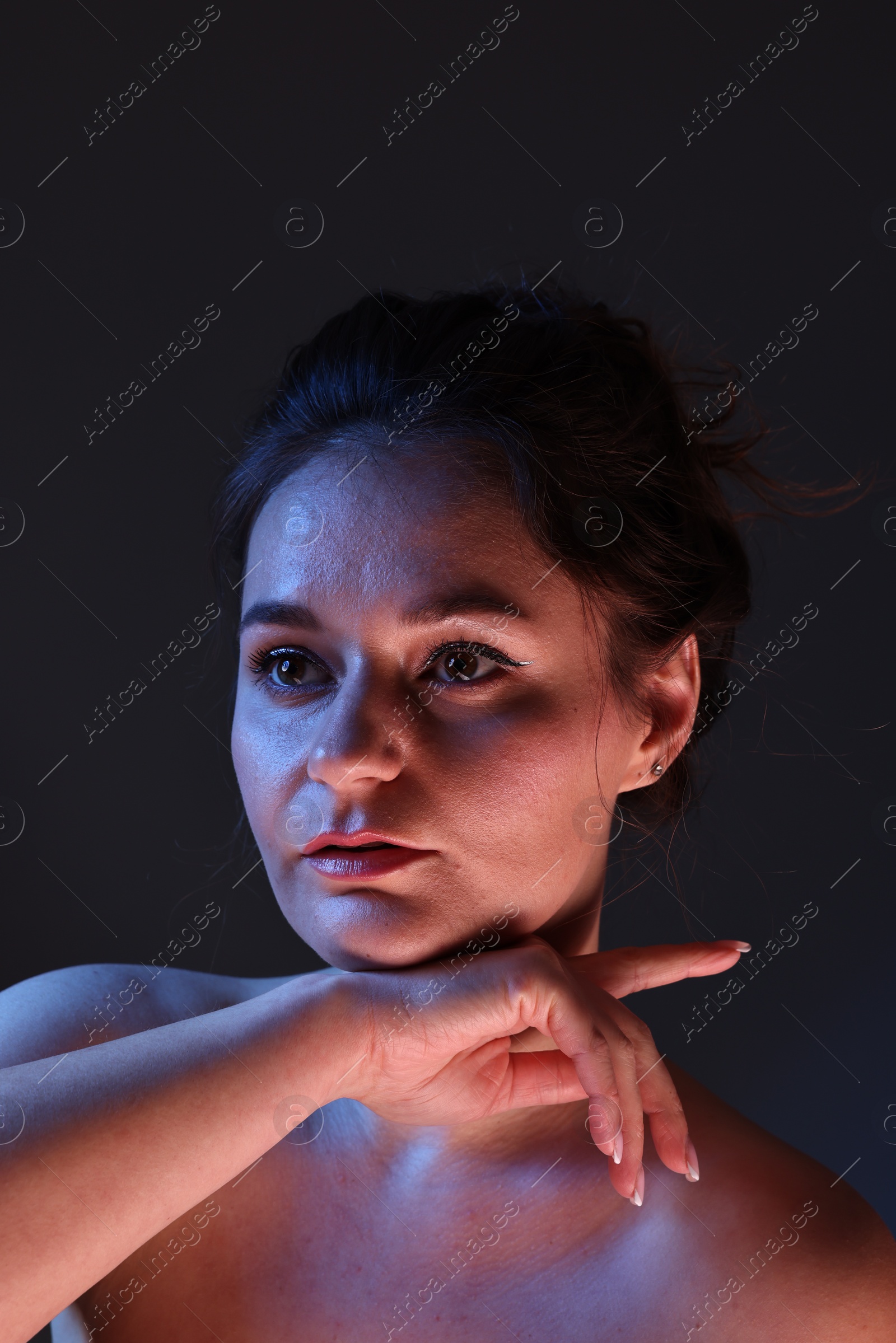 Photo of Portrait of beautiful young woman on dark background
