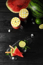Photo of Slate board with smoothie, juicy watermelon, ice and lime on black wooden table, flat lay