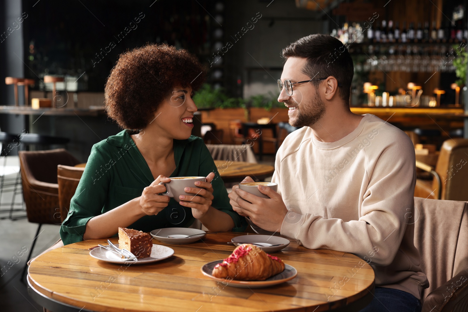 Photo of International dating. Lovely couple spending time together in cafe