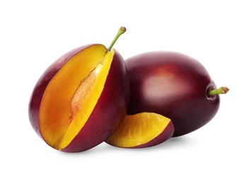 Whole and cut ripe plums on white background