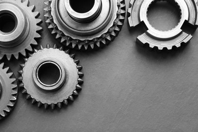 Photo of Different stainless steel gears on grey background, flat lay. Space for text