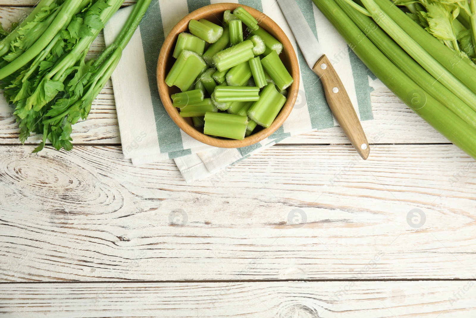 Photo of Fresh ripe green celery on white wooden table, flat lay. Space for text