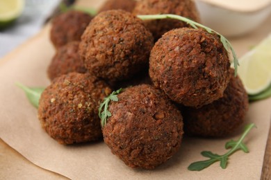 Photo of Delicious falafel balls and arugula on table, closeup