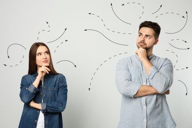 Image of Choice in profession or other areas of life, concept. Making decision, thoughtful young man and woman surrounded by drawn arrows on light background