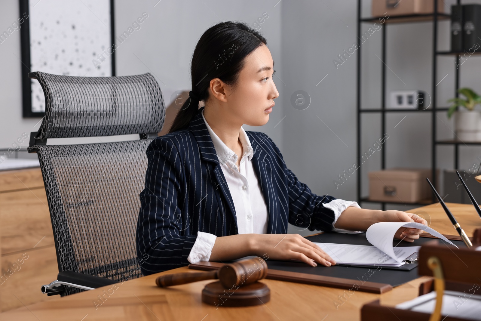 Photo of Notary reading document at table in office