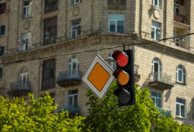 View of traffic light and road sign in city, space for text