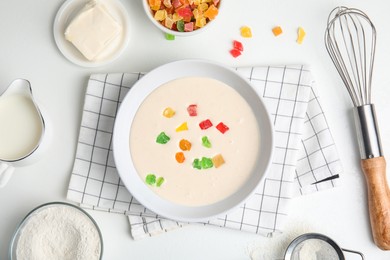 Flat lay composition with raw dough, candied fruits and other ingredients for cookies on white table