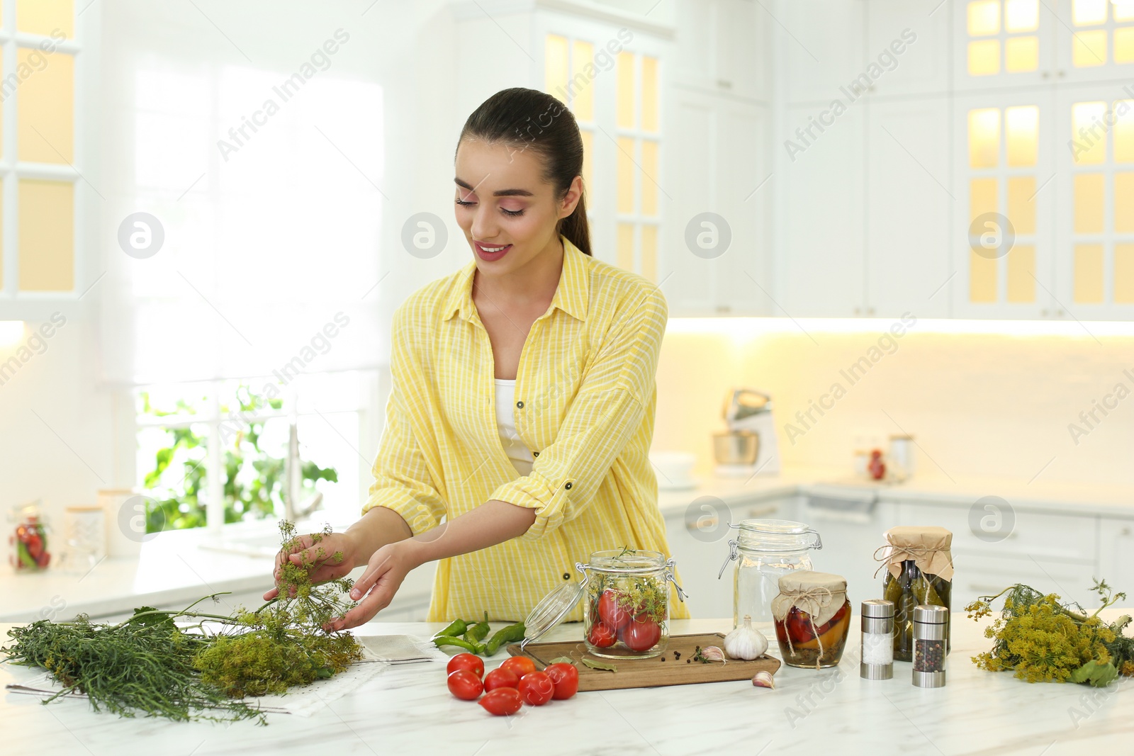 Photo of Woman preparing pickled vegetables at table in kitchen