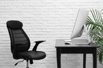 Photo of Stylish workplace interior with modern office chair