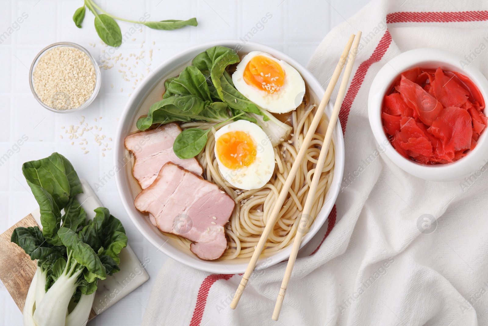 Photo of Delicious ramen with meat served on white tiled table, flat lay. Noodle soup