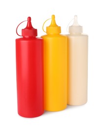 Photo of Plastic bottles of tasty mayonnaise, ketchup and mustard on white background