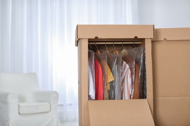 Wardrobe boxes with clothes in living room. Space for text