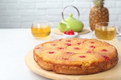 Photo of Tasty pineapple cake with cherries on white table. Space for text