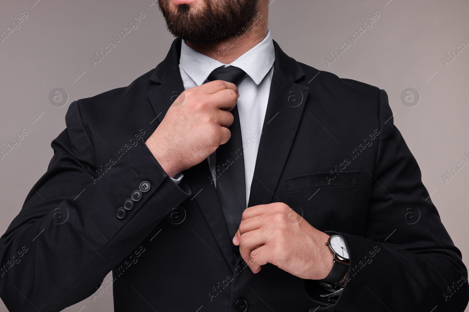 Photo of Businessman in suit and necktie on grey background, closeup
