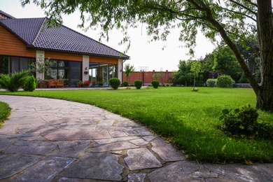 Beautiful landscape with green garden near modern house on sunny day