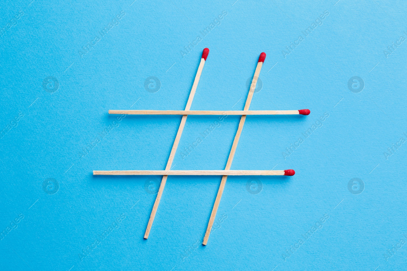 Photo of Hashtag symbol of matches on turquoise background, top view