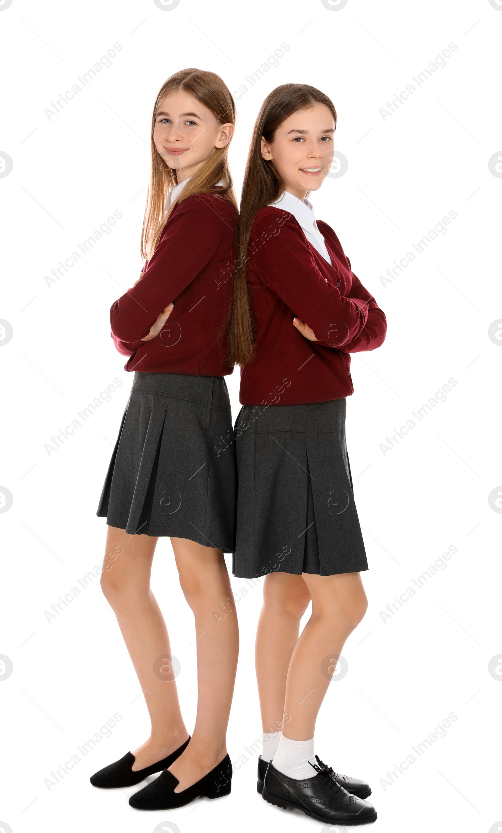 Photo of Full length portrait of teenage girls in school uniform on white background