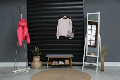 Photo of Hallway interior with stylish furniture, clothes and accessories