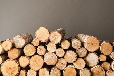 Photo of Cut firewood on grey background. Heating in winter