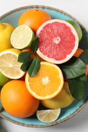 Photo of Different cut and whole citrus fruits on white table, top view