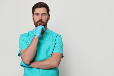 Nurse in medical uniform on white background, space for text