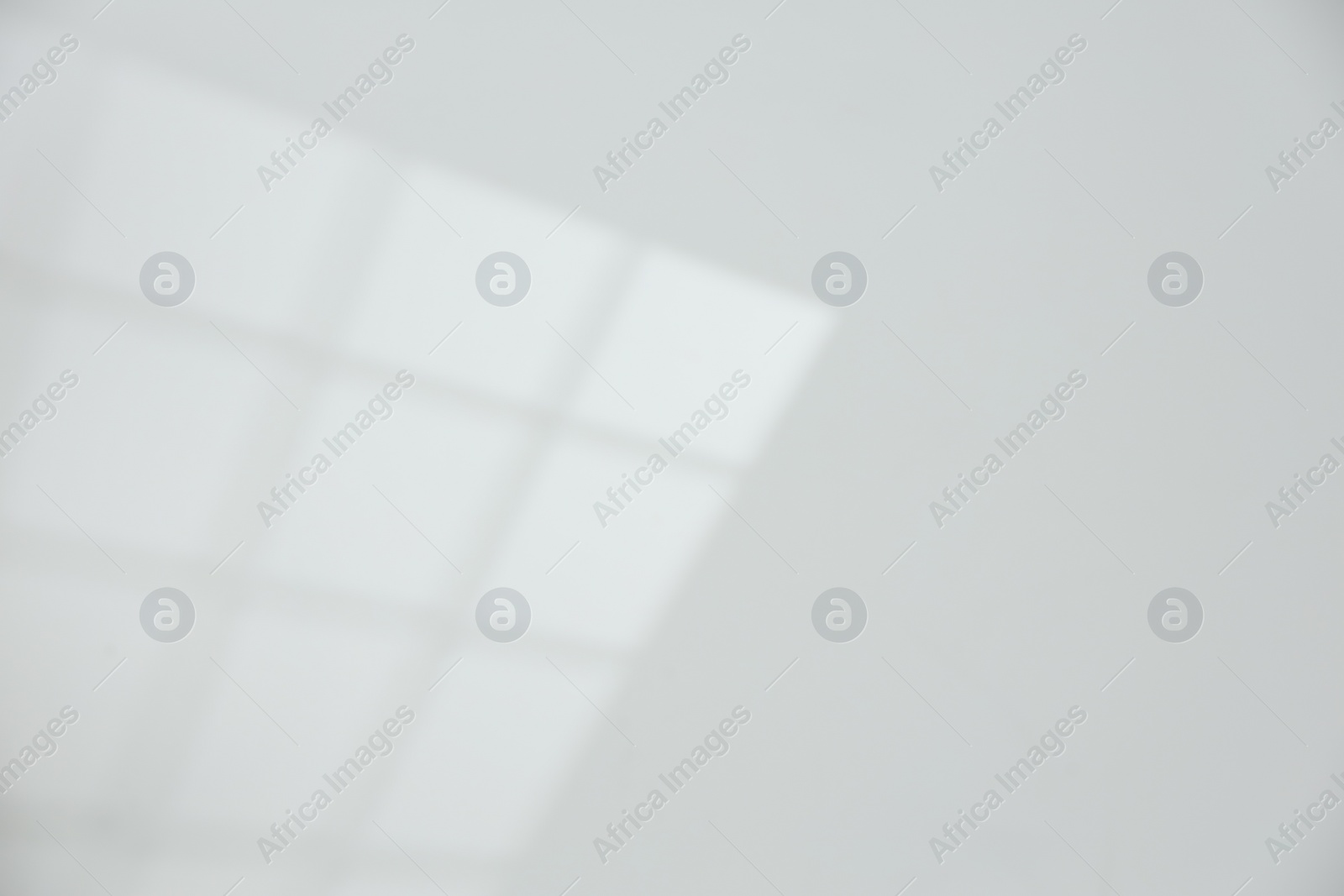 Photo of Light and shadow from window on white wall, space for text