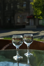 Photo of Two glasses of water at table in cafe, after coffee refreshing drink