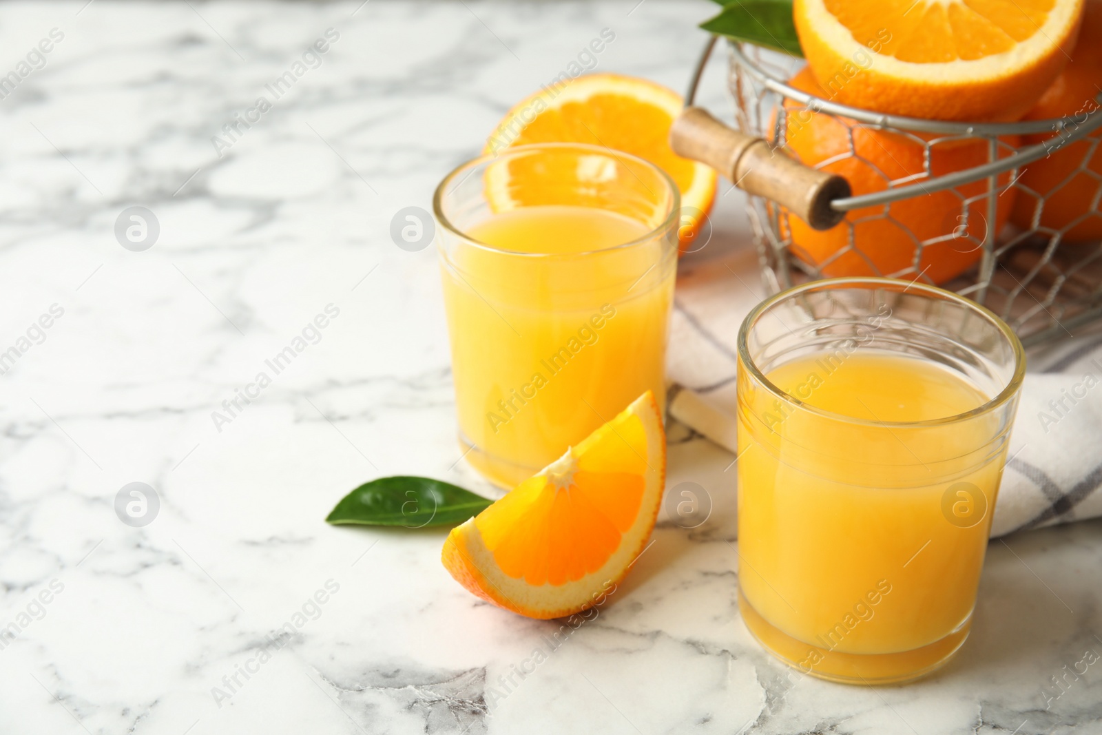 Photo of Composition with orange juice and fresh fruit on marble background, space for text