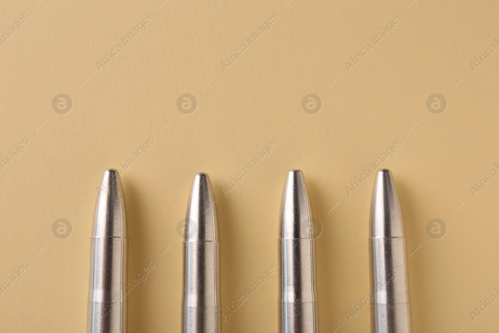 Photo of Many metal bullets on yellow background, flat lay. Space for text