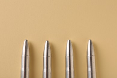 Photo of Many metal bullets on yellow background, flat lay. Space for text