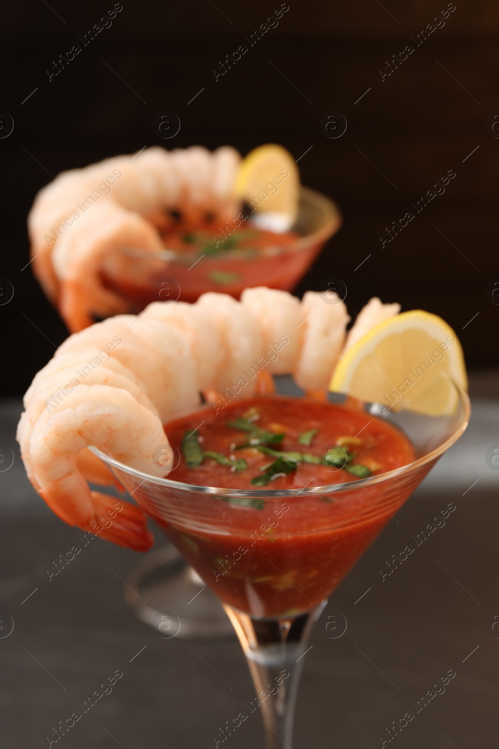 Photo of Tasty shrimp cocktail with sauce in glasses on table closeup