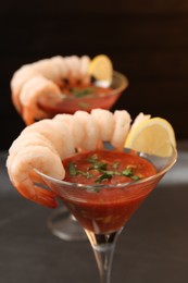 Photo of Tasty shrimp cocktail with sauce in glasses on table closeup