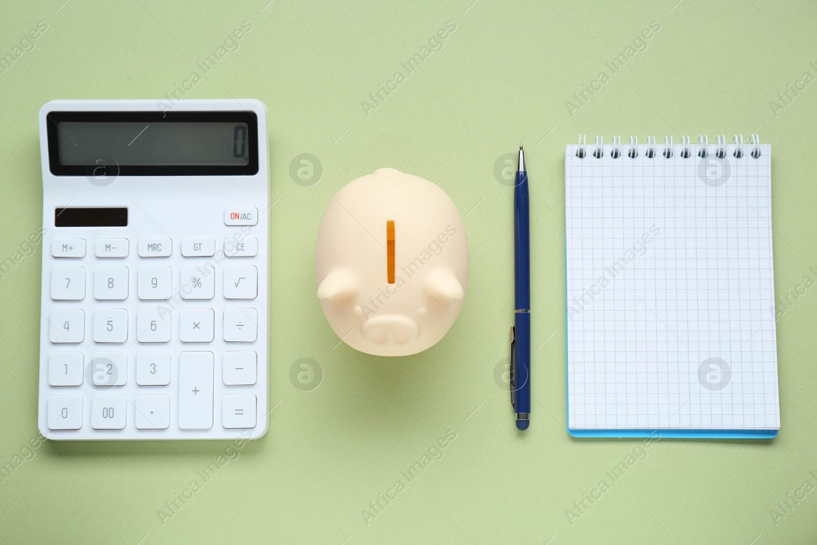 Photo of Piggy bank, notebook and calculator on light green background, flat lay