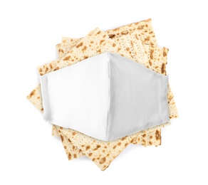 Image of Coronavirus pandemic. Passover matzos and protective face mask on white background, top view